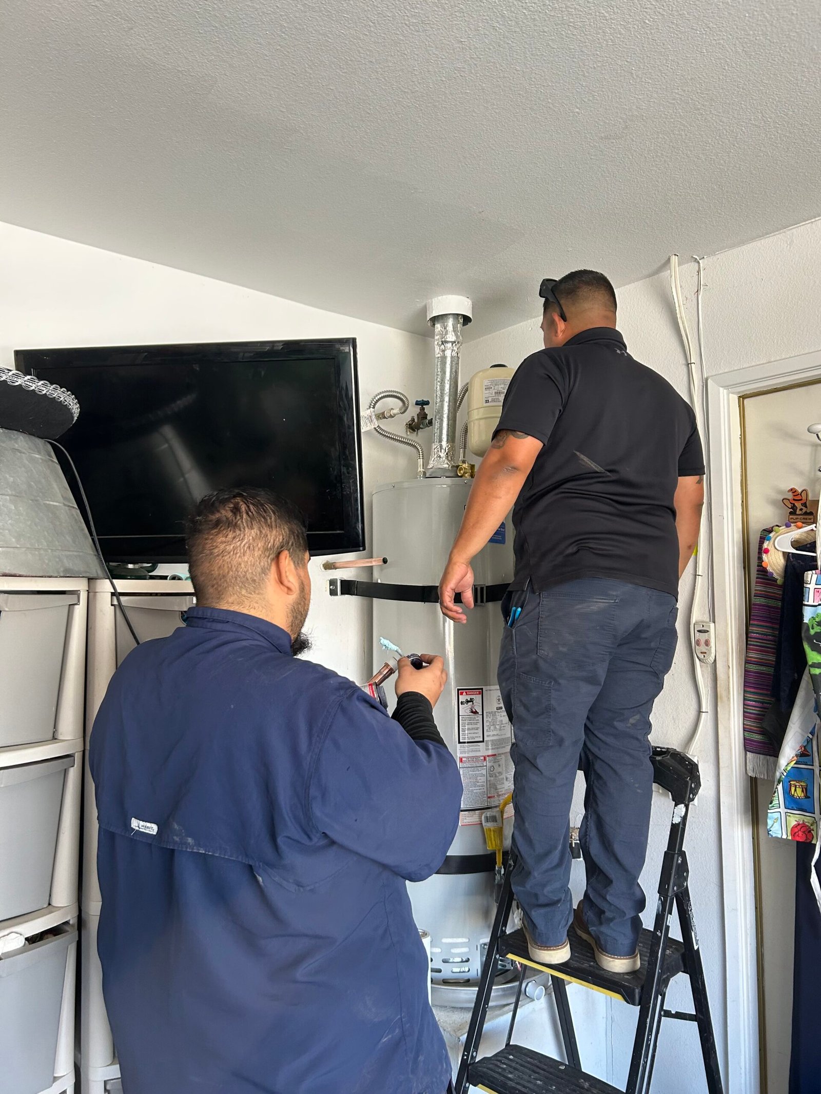 Plumbers installing a water heater